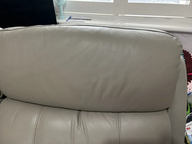 Light-grey leather headrest after colour restoration