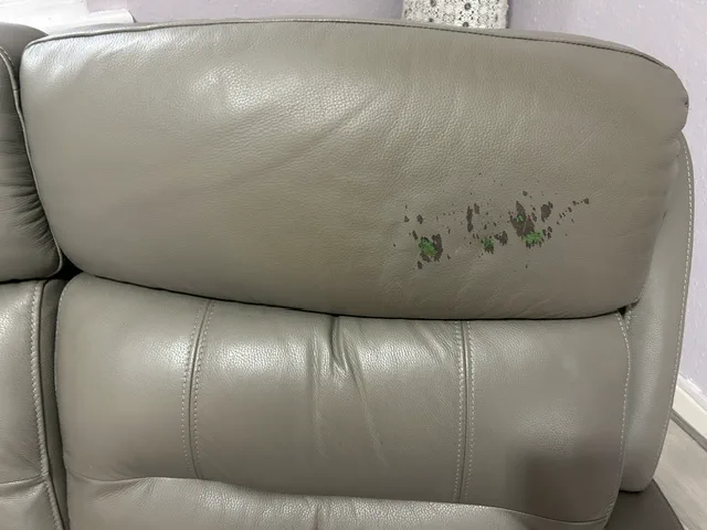Worn and marked light-grey leather headrest before colour restoration