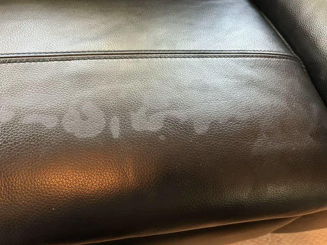 Dark-brown leather sofa seat with white surface marking before colour repair