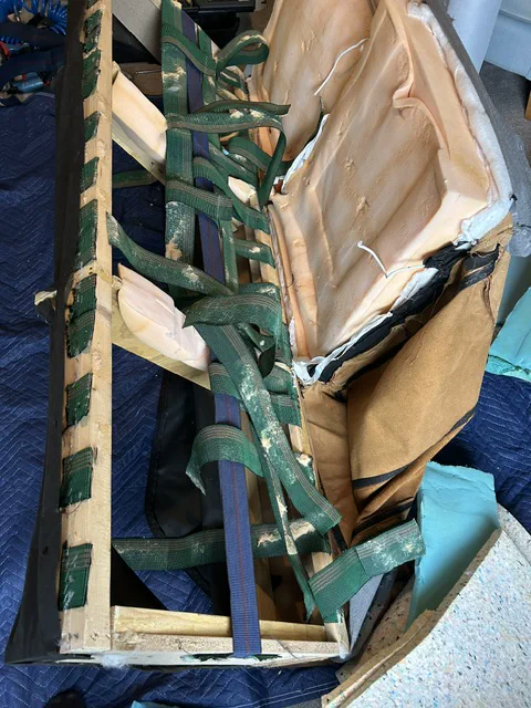 Damaged sofa seat frame and webbing before repair